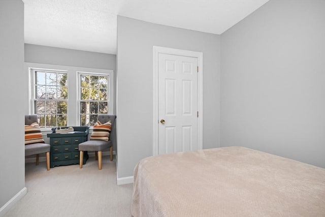 bedroom with baseboards and light colored carpet