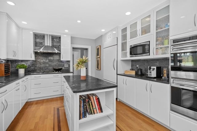 kitchen with open shelves, wall chimney range hood, and white cabinetry