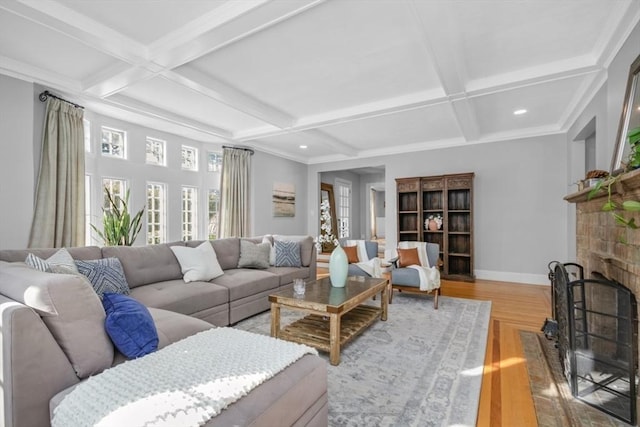 living room with a brick fireplace, baseboards, coffered ceiling, and wood finished floors