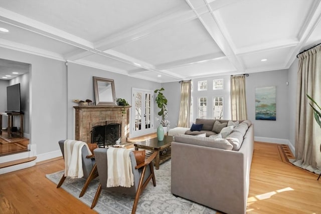 living room with coffered ceiling, a fireplace, light wood-style flooring, and baseboards