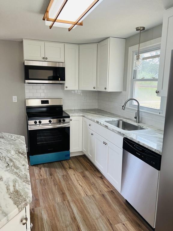 209 Casey Dr, Chicopee, MA 01020 - kitchen featuring appliances with stainless steel finishes, white cabinets, tasteful backsplash, and light stone counters