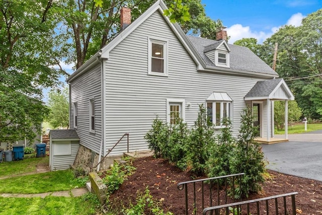 25 Norfolk St, Canton, MA 02021 - view of side of home featuring a chimney and a shingled roof