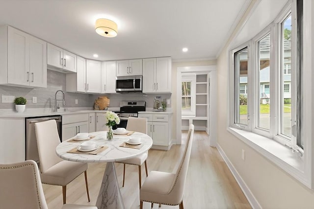 25 Norfolk St, Canton, MA 02021 - kitchen featuring stainless steel appliances, healthy amount of natural light, white cabinetry, ornamental molding, and recessed lighting