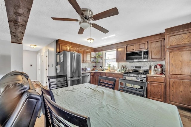 14 Greenville St, Billerica, MA 01821 - kitchen featuring a ceiling fan, brown cabinetry, appliances with stainless steel finishes, and decorative backsplash