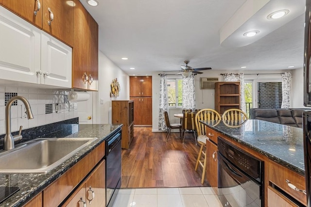 kitchen featuring brown cabinetry, a ceiling fan, a sink, black appliances, and recessed lighting