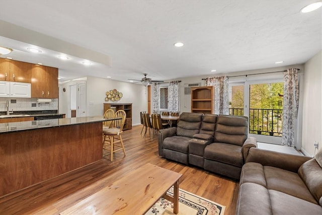 living area featuring recessed lighting, light wood finished floors, ceiling fan, and baseboards