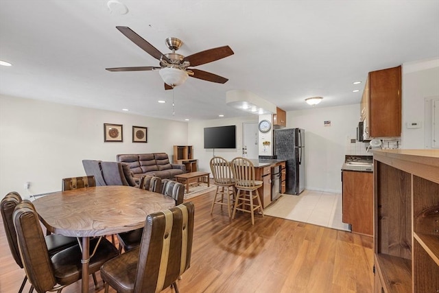 dining area featuring light wood-type flooring, a ceiling fan, and recessed lighting