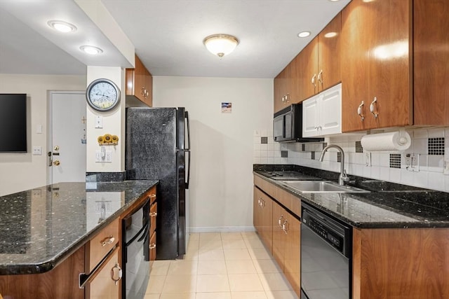 kitchen featuring brown cabinetry, baseboards, a sink, light tile patterned floors, and black appliances