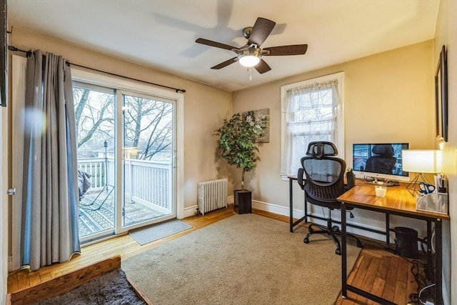 office area featuring ceiling fan, radiator heating unit, and light hardwood / wood-style floors