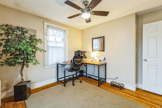 home office with wood-type flooring and ceiling fan