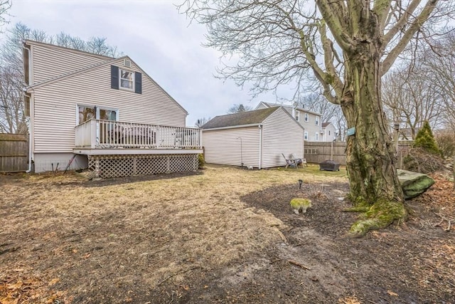 back of property with a wooden deck and a storage unit