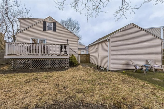 rear view of house featuring a yard and a deck