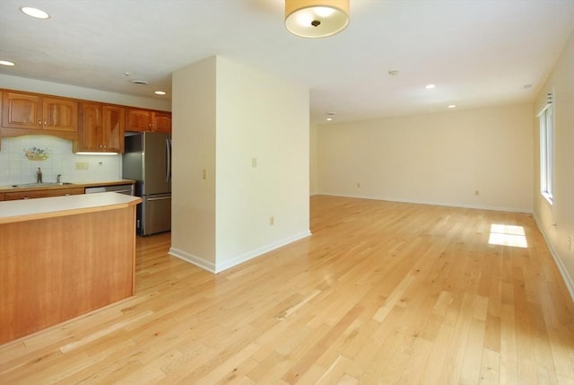 19 Concord Greene Unit 3, Concord, MA 01742 - kitchen with freestanding refrigerator, light countertops, light wood-style floors, recessed lighting, and tasteful backsplash