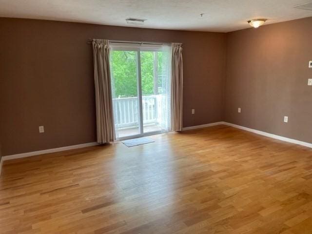 unfurnished room with baseboards and light wood finished floors