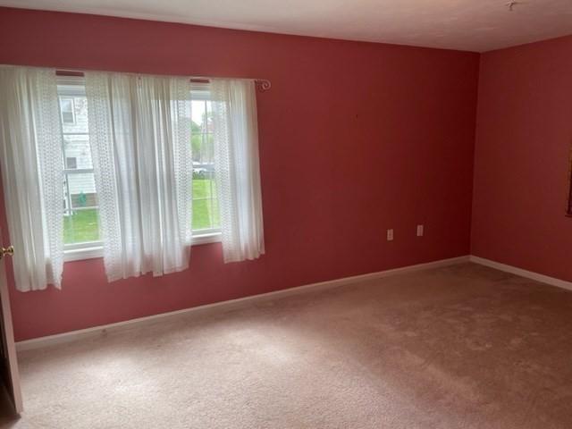carpeted spare room with baseboards