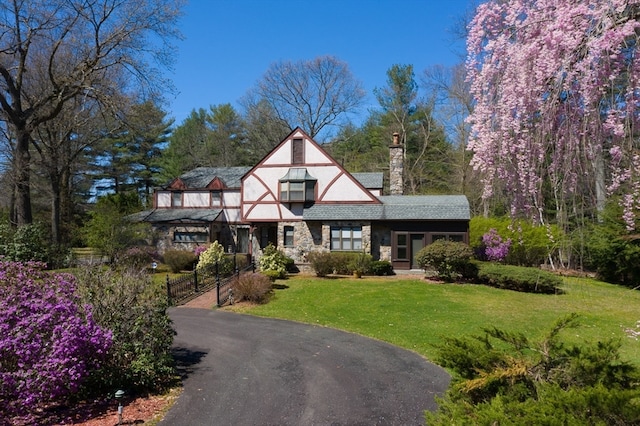 tudor-style house featuring a front yard