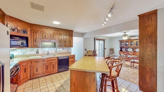 242 Eastwood Dr, Westfield, MA 01085 - kitchen featuring black appliances, a sink, light countertops, light tile patterned flooring, and a kitchen bar