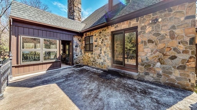 242 Eastwood Dr, Westfield, MA 01085 - doorway to property with stone siding, a shingled roof, a chimney, and a patio