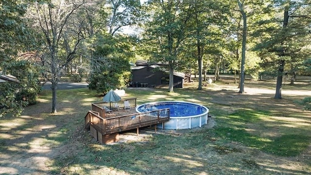 242 Eastwood Dr, Westfield, MA 01085 - view of green lawn with a wooden deck, an outdoor pool, and view of wooded area