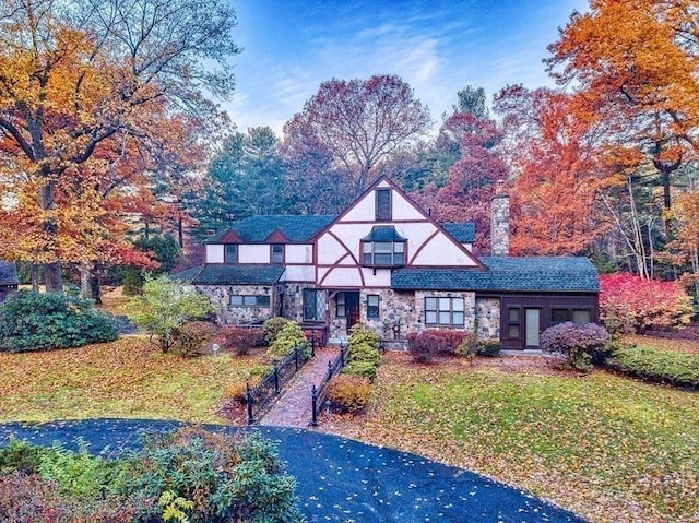 242 Eastwood Dr, Westfield, MA 01085 - tudor-style house featuring a front yard, stone siding, a chimney, and stucco siding