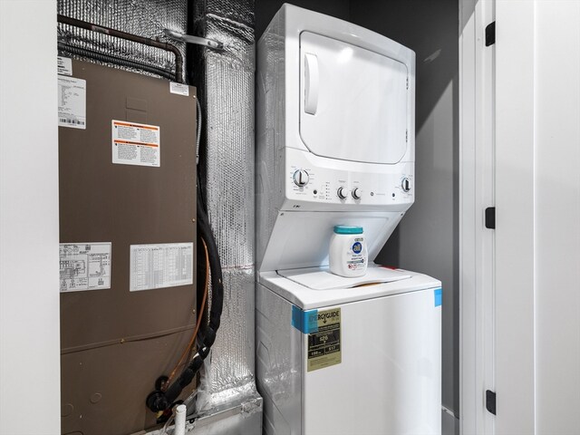 clothes washing area featuring stacked washing maching and dryer