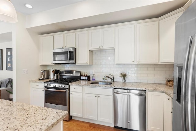 129 Highland Ave Unit 4, Somerville, MA 02143 - kitchen featuring stainless steel appliances, white cabinetry, and tasteful backsplash
