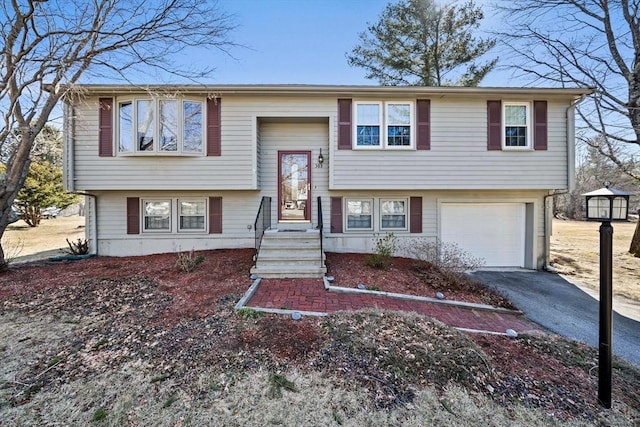 split foyer home featuring aphalt driveway and an attached garage