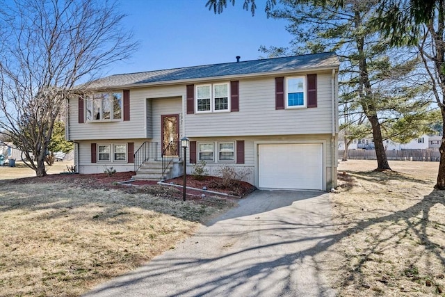 split foyer home with aphalt driveway and an attached garage