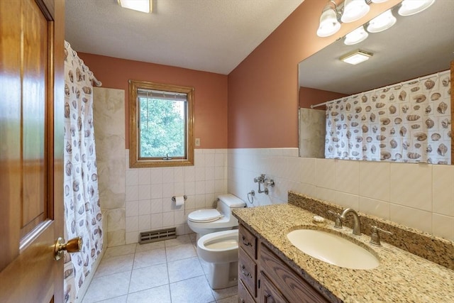 1170 E St, Ludlow, MA 01056 - full bathroom featuring a bidet, tile patterned floors, tile walls, vanity, and a shower with shower curtain