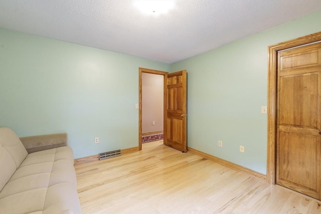 1170 E St, Ludlow, MA 01056 - unfurnished living room featuring light wood-style flooring and a textured ceiling