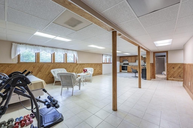 1170 E St, Ludlow, MA 01056 - basement featuring wood walls, a wainscoted wall, a drop ceiling, and tile patterned flooring