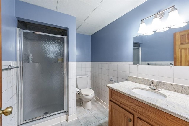 1170 E St, Ludlow, MA 01056 - bathroom with vanity, a shower stall, tile patterned floors, tile walls, and a wainscoted wall