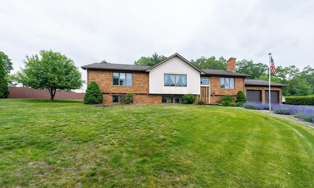 1170 E St, Ludlow, MA 01056 - bi-level home featuring a chimney, a garage, brick siding, and asphalt driveway