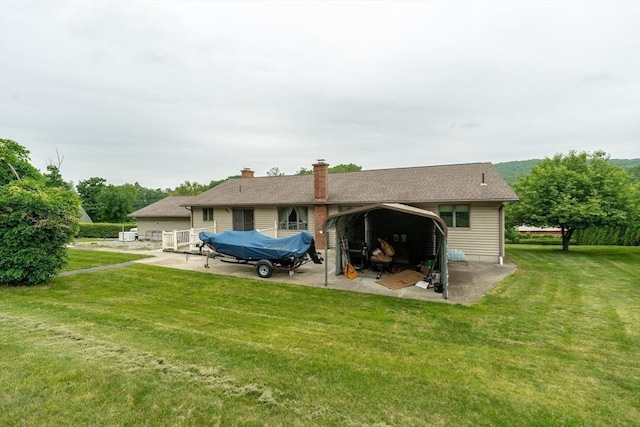 1170 E St, Ludlow, MA 01056 - back of house with a lawn, a patio, a detached carport, and a chimney