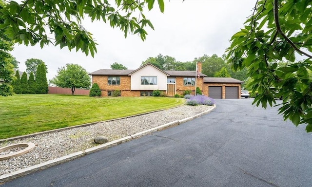 1170 E St, Ludlow, MA 01056 - view of front of property featuring a chimney, driveway, brick siding, and an attached garage