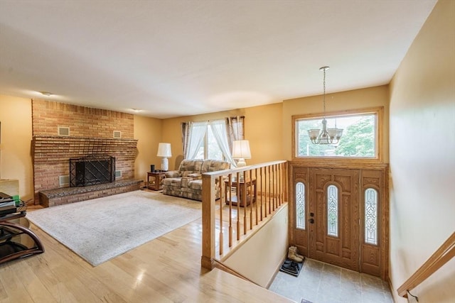 1170 E St, Ludlow, MA 01056 - foyer entrance with a chandelier, a brick fireplace, and wood finished floors