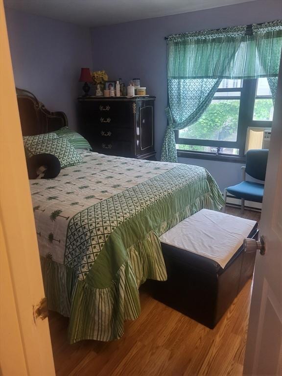 21 Delford Unit 2, Boston, MA 02131 - bedroom with wood finished floors and a baseboard heating unit
