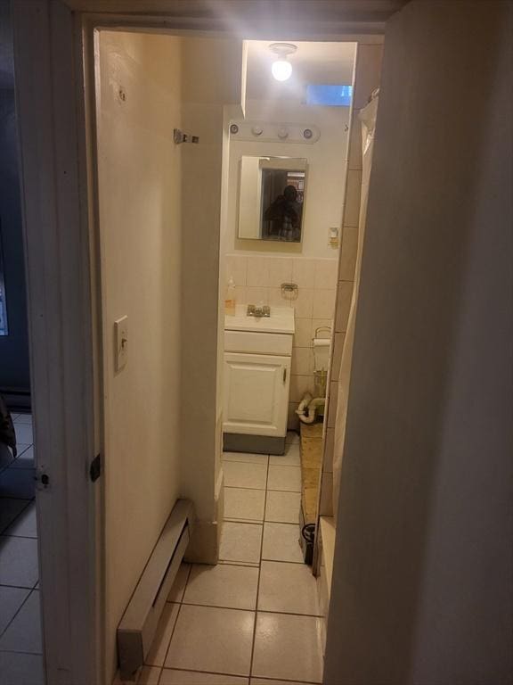 21 Delford Unit 2, Boston, MA 02131 - corridor featuring baseboard heating, light tile patterned floors, and tile walls