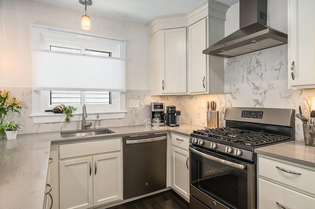 kitchen featuring a sink, decorative backsplash, stainless steel appliances, and wall chimney exhaust hood