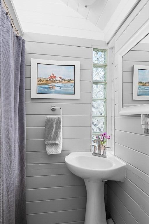 full bathroom with wood walls