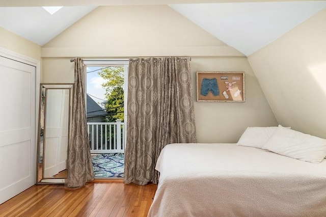 bedroom featuring wood-type flooring, lofted ceiling, and access to outside