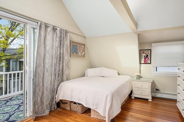 bedroom featuring a baseboard heating unit, wood finished floors, and lofted ceiling