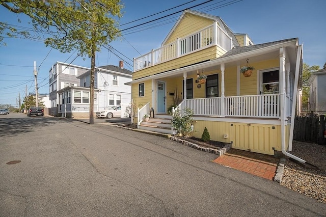 view of front of home featuring a porch, a shingled roof, and a balcony