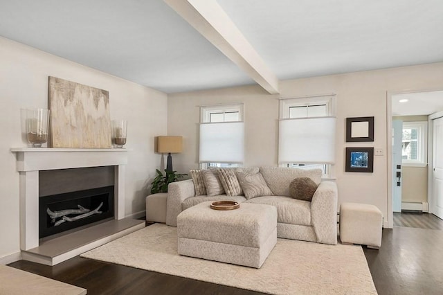 living area with a fireplace with raised hearth, beam ceiling, baseboard heating, and dark wood-style floors