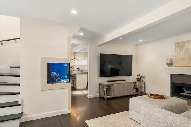 living area with recessed lighting, baseboards, stairs, and wood finished floors