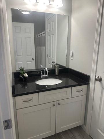 full bath featuring vanity and wood finished floors