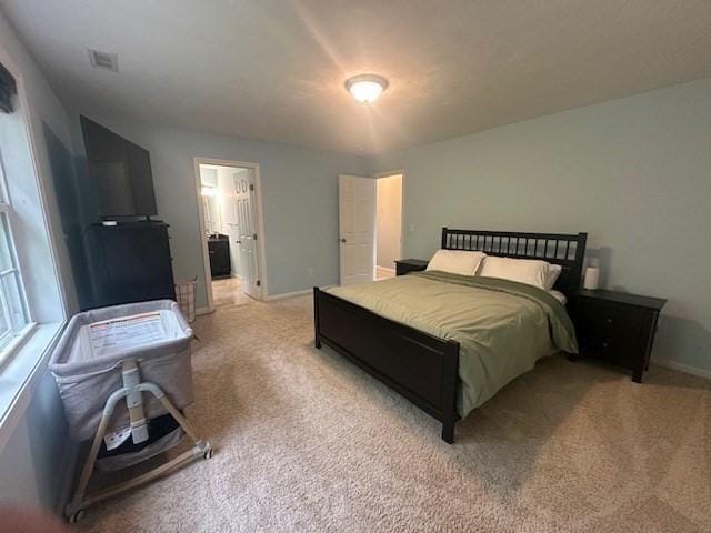 bedroom with light colored carpet and baseboards