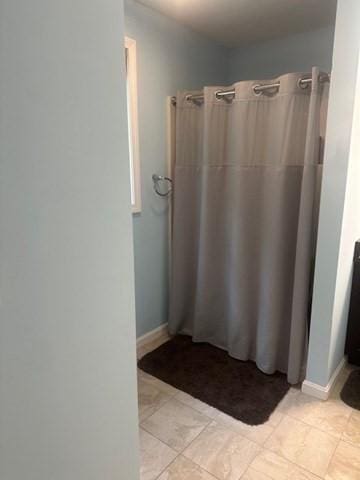 bathroom with a shower with curtain and baseboards