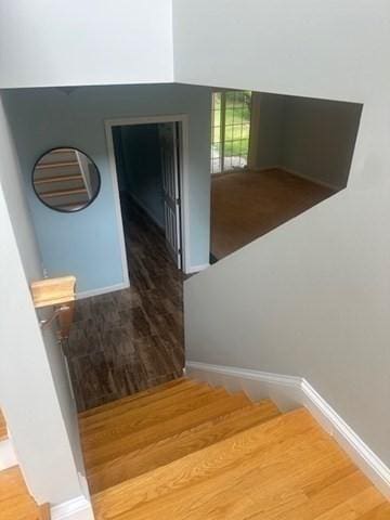 stairway featuring wood finished floors and baseboards