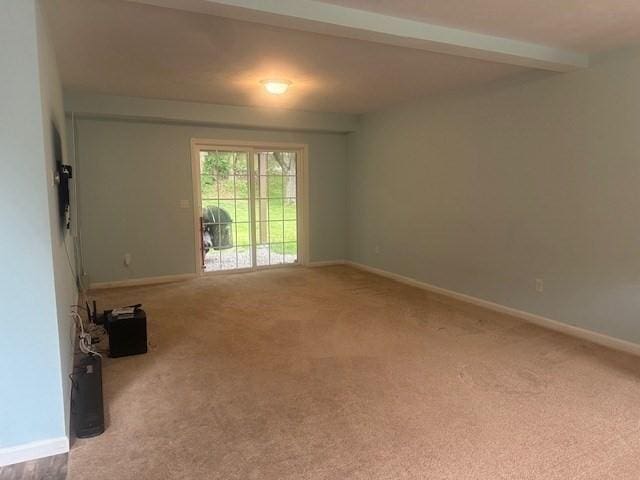 carpeted empty room with baseboards and beamed ceiling